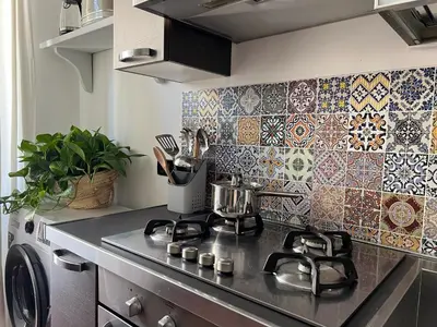 a kitchen with a stove and a tile wall at Pothos House in Palermo