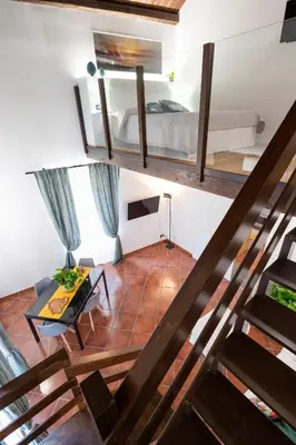a view of a room with a bed and a staircase at Pothos House in Palermo