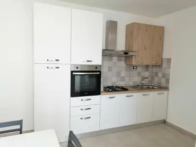 a kitchen with white cabinets and a tv in it at Residence Mare Azzurro in Balestrate
