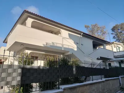 a white house with a black fence at Residence Mare Azzurro in Balestrate