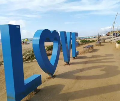 a large blue sign on the beach at Residence Mare Azzurro in Balestrate