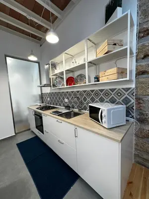 a kitchen with white cabinets and a microwave on a counter at Le Gemelle Diverse in Cinisi