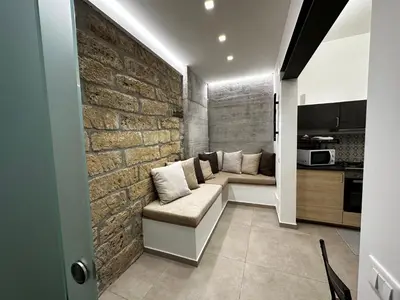 a living room with a couch and a brick wall at Le Gemelle Diverse in Cinisi