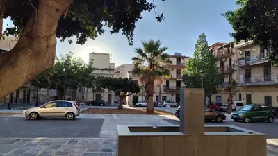 a building with two doors and a fan at La Casetta Nell' Atrio Cavalieri in Bagheria