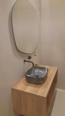 a stone sink on a wooden counter with a mirror at I Faraglioni Comfort Rooms in Terrasini