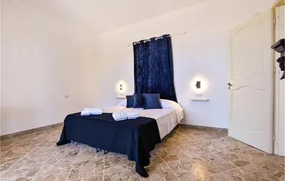 a bedroom with a bed with a blue curtain at Gorgeous Home In Terrasini in Terrasini