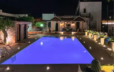 a swimming pool with blue lighting in front of a house at Gorgeous Home In Terrasini in Terrasini