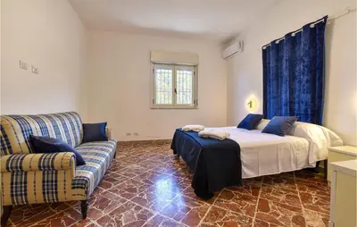 a bedroom with a bed and a couch at Gorgeous Home In Terrasini in Terrasini