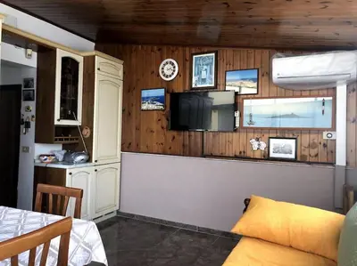 a living room with a couch and a tv on a wall at La casa di Maria in Isola delle Femmine