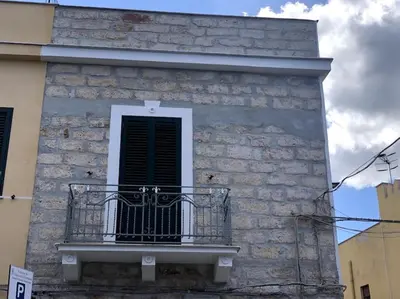 a balcony on a brick building with a window at La casa di Maria in Isola delle Femmine