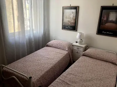 a room with two beds and a window at La casa di Maria in Isola delle Femmine