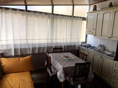 a small kitchen with a table and a sink at La casa di Maria in Isola delle Femmine