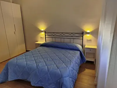 a bedroom with a bed with a blue comforter at Mondello Sea House in Palermo