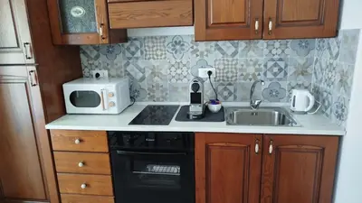 a kitchen with a sink and a microwave at Mondello Sea House in Palermo