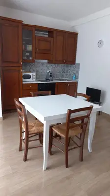 a kitchen with a white table and wooden chairs at Mondello Sea House in Palermo