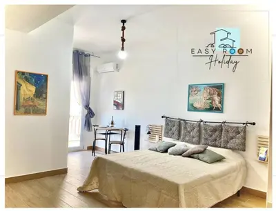 a bedroom with a bed and a table in it at Easy Room Holiday in Castellammare del Golfo
