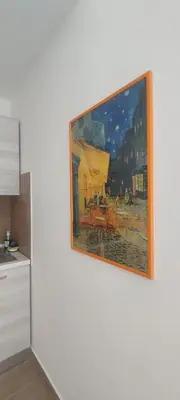 a painting hanging on a wall in a kitchen at Easy Room Holiday in Castellammare del Golfo