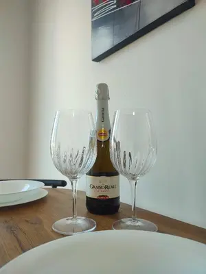 two wine glasses and a bottle on a table at Easy Room Holiday in Castellammare del Golfo