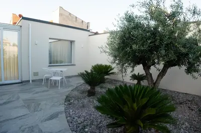a patio with a table and chairs and trees at Hotel La Martinica in Ficarazzi