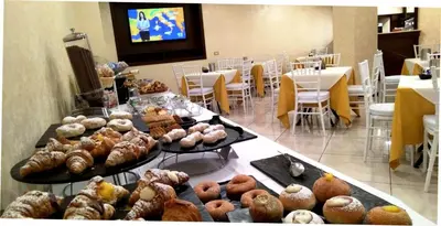 a table filled with different types of pastries at Hotel La Martinica in Ficarazzi