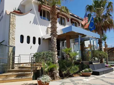 a house with a palm tree in front of it at Hotel La Martinica in Ficarazzi