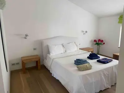 a bedroom with a white bed with towels on it at Villa Elloise in Palermo