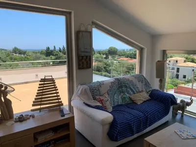 a living room with a couch and a large window at Villa Elloise in Palermo
