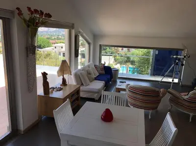 a living room with a couch and a table and chairs at Villa Elloise in Palermo