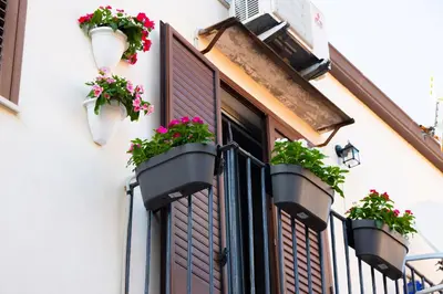 a window with flowerpots on the side of a building at Pozzillo appartament -near the cathedral in Monreale