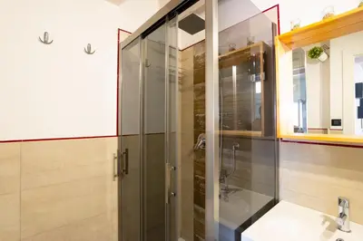 a bathroom with a glass shower and a sink at Pozzillo appartament -near the cathedral in Monreale