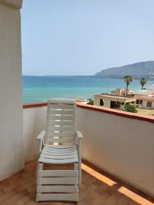 a white chair sitting on a balcony overlooking the ocean at sizilien in Trappeto