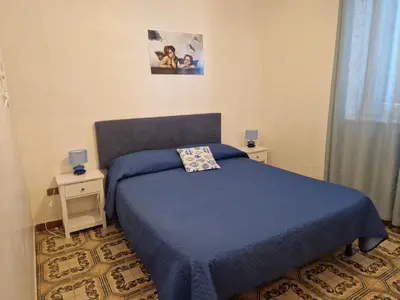 a bedroom with a blue bed and two night stands at sizilien in Trappeto