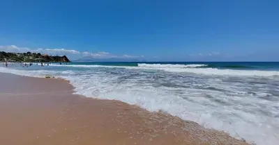 a beach with the ocean and a group of people at sizilien in Trappeto