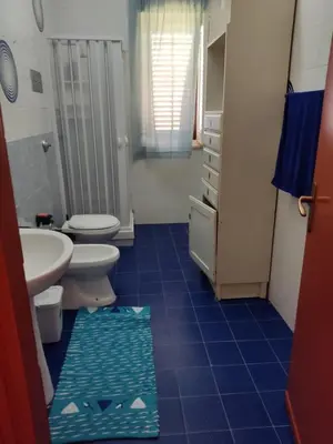 a bathroom with two toilets and a sink and a rug at sizilien in Trappeto