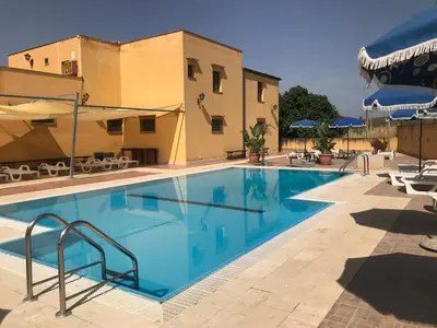 a swimming pool in front of a building at Baglio Pocoroba in Calatafimi