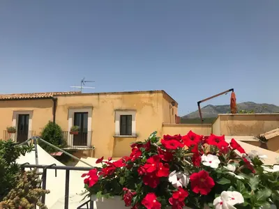 a bunch of red and white flowers on a balcony at Baglio Pocoroba in Calatafimi