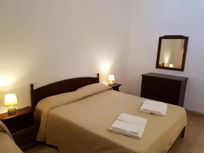 a bedroom with a bed with a mirror and two towels at Baglio Pocoroba in Calatafimi