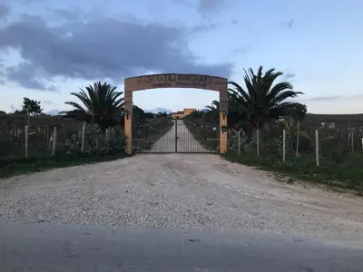 an entrance to a gate with a fence and a road at Baglio Pocoroba in Calatafimi