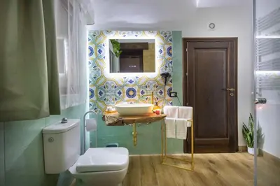 a bathroom with a sink and a toilet and a mirror at Tri Re e 'na Regina in Cinisi