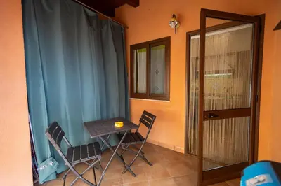 a small table and chairs in a room with a door at Tri Re e 'na Regina in Cinisi