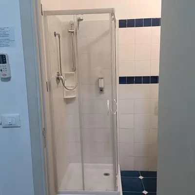 a shower with a glass door in a bathroom at DayBreak B&B in Palermo