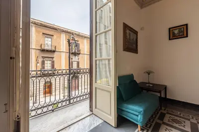 a green chair in a room with a window at Amari Elegant Apartment by Wonderful Italy in Palermo