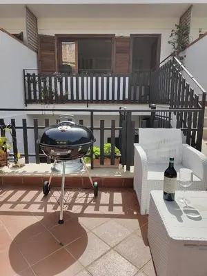 a grill sitting on a patio with two chairs at Casa Antigone 99 in Mondello