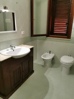 a bathroom with a sink and a toilet and a mirror at Casa Antigone 99 in Mondello