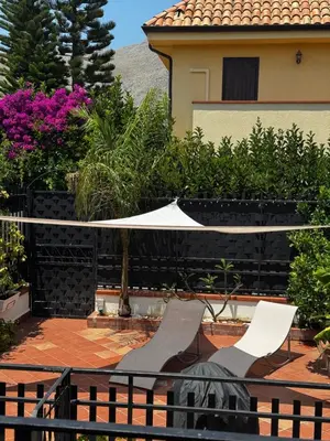 a patio with two chairs and an umbrella at Casa Antigone 99 in Mondello