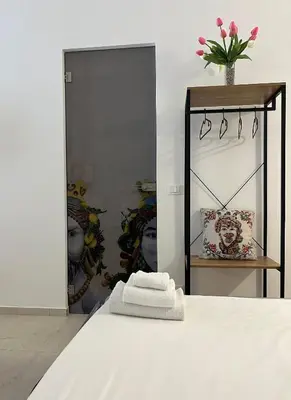 a bedroom with a white bed and a mirror at Sicilian Paradise Casa Vacanze in Castellammare del Golfo
