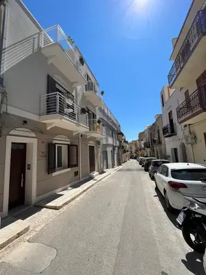 an empty street with cars parked in front of buildings at Sicilian Paradise Casa Vacanze in Castellammare del Golfo