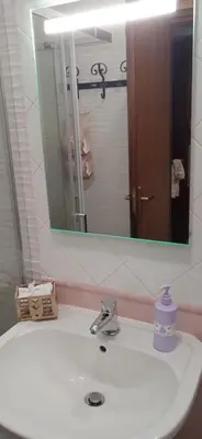 a bathroom sink with a mirror and a bottle of soap at AI CANTIERI in Palermo