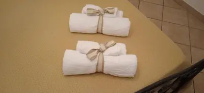 three rolls of towels tied with bows on a table at AI CANTIERI in Palermo