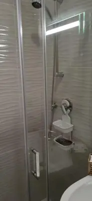 a shower with a glass door next to a sink at AI CANTIERI in Palermo